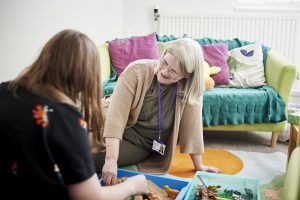 Image of counsellor with toys in a comforting counselling room